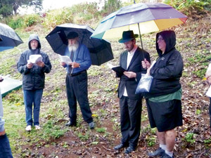The first-ever Jewish cemetery on Kaua'i was consecrated Jan. 13 at Kalapaki Memorial Cemetery grounds. The dedication was held during a downpour prior to the funeral of Dr. Francine Snyder, the first person to be buried there. Pictured (from left) are Ken Solin, Richard Seigel, Rabbi Michoel Goldman and David Leopold | Photo from Kimo Rosen