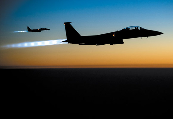 A pair of U.S. F-15E Strike Eagle flies over northern Iraq Sept. 23 after conducting airstrikes in Syria. U.S.-led coalition warplanes bombed oil installations and other facilities in territory controlled by Islamic State militants in eastern Syria Sept. 26, taking aim for a second consecutive day at a key source of financing that has swelled the extremist group's coffers, activists said. AP Photo/U.S. Air Force, Matthew Bruch