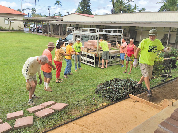 Rotarians help create a paved area for Hanalei Elementary School students to cross over muddy terrain | Hanalei Rotary photo 