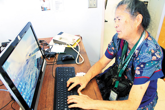 Miyashiro keeps a positive attitude and continues to help out around Friendship House, including working on a computer specifi cally designed for those who are blind 