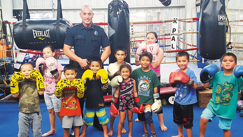 Officer Mitchell Collier with keiki from one of KPAL's boxing classes PHOTO COURTESY OF KPD 