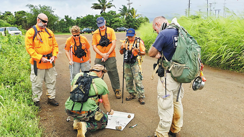 Ex-military operative and team member Dan Johanknecht puts tracking, GPS, map and compass work together for search efforts. Other team members pictured: Timothy O'Rourke, Debra and David Gochros, Azi and Jim Turturici (Photo courtesy of Peter Kahapea)