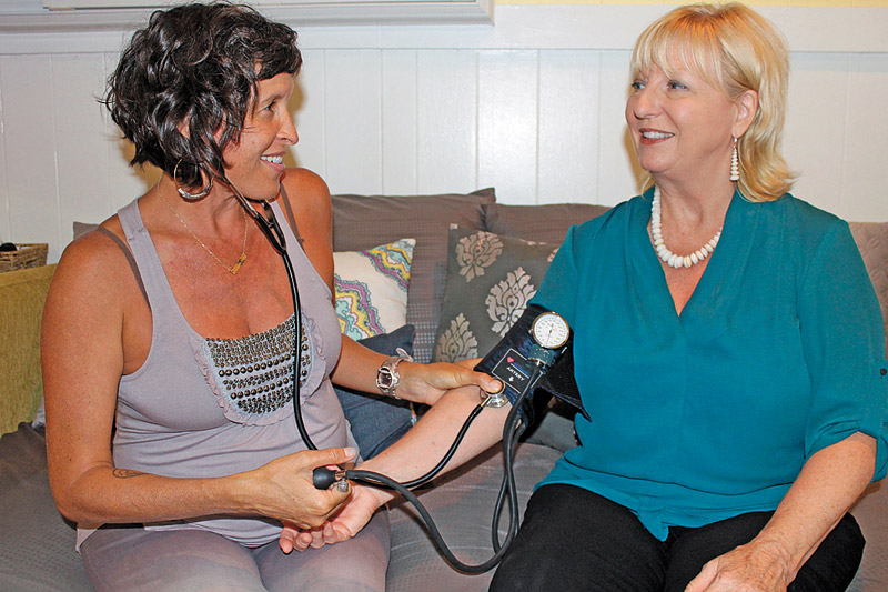 Midwife and women's wellness practitioner Colleen Bass checks Nellie Foster's blood pressure at Makai Ola, where they both offer their own health care services 