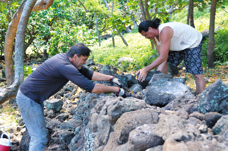 Wichman's husband, Randy, and Dr. Keao NeSmith restoring the ‘Malama Wall' in Nualolo Kai 