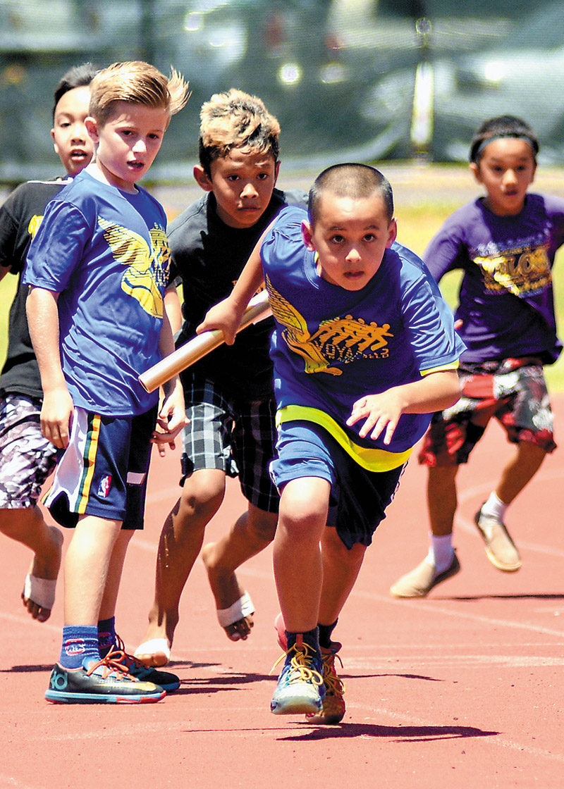 Island School's Matthew Dobashi takes off after getting the baton in the 400-meter relay (grades 2-3) 