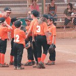 Orioles coach Justin Molina encourages his team between innings