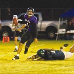 Kaua‘i quarterback Chris Mundon scrambles to avoid a tackle