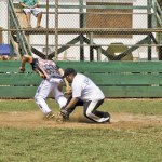 An Outlaw baserunner eludes the tag and touches home plate.