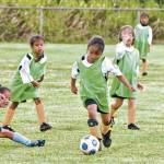 A Makani Gold player canâ€™t bear to watch as her teammate races ahead with the ball.